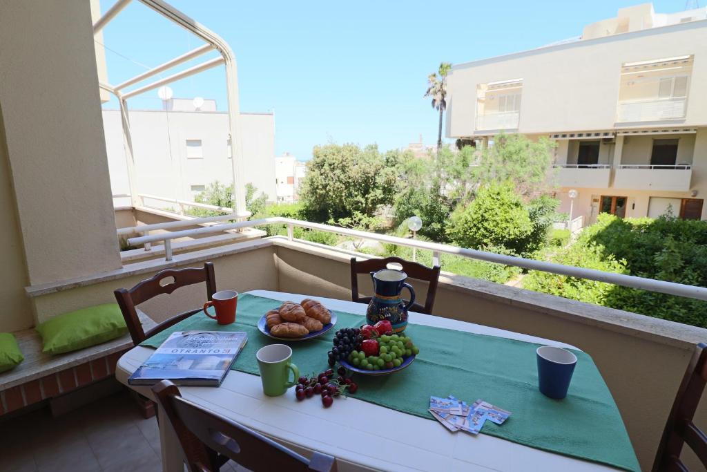un tavolo con un cesto di frutta sul balcone di Casa vacanze Nicole in Salento 5 posti a Otranto