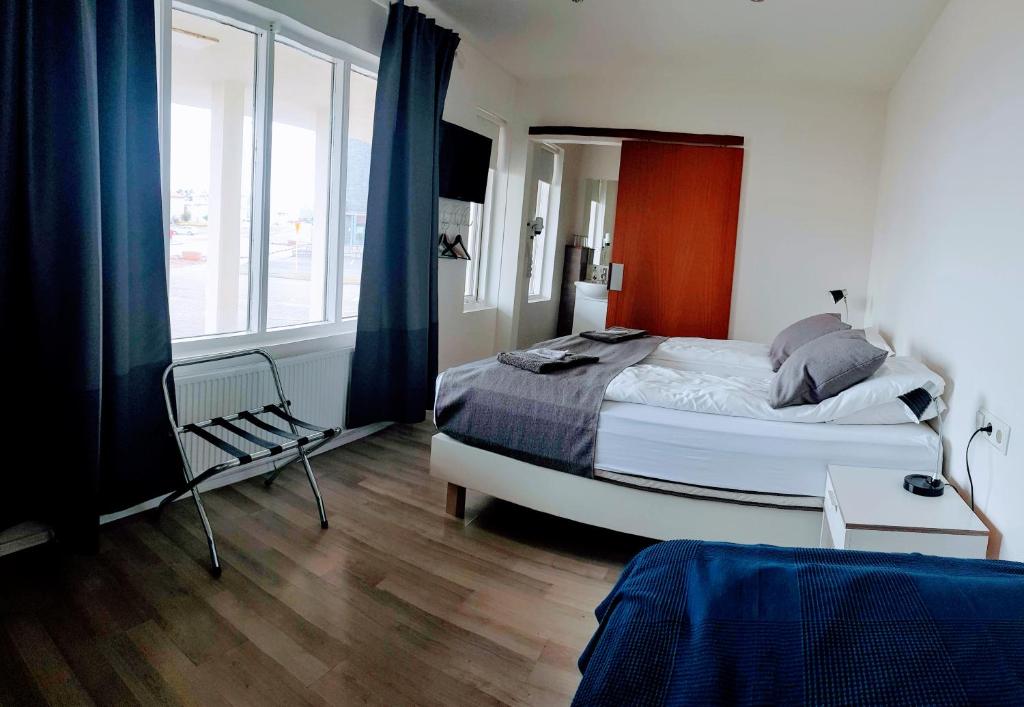 1 dormitorio con cama y ventana grande en Apotek Guesthouse en Höfn