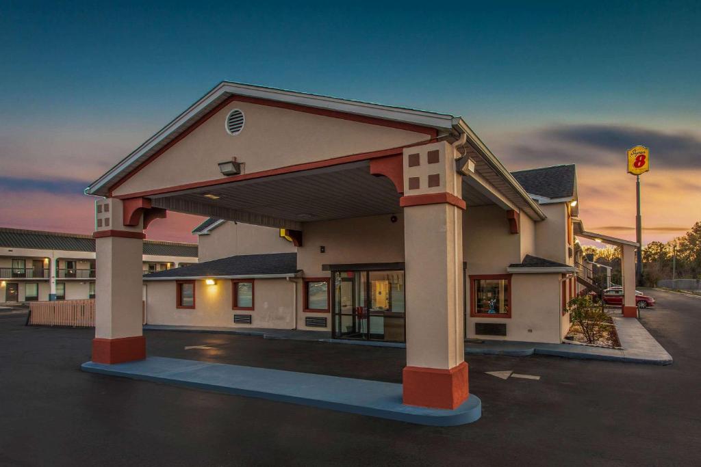a building with a parking lot in front of it at Super 8 by Wyndham Florence in Florence