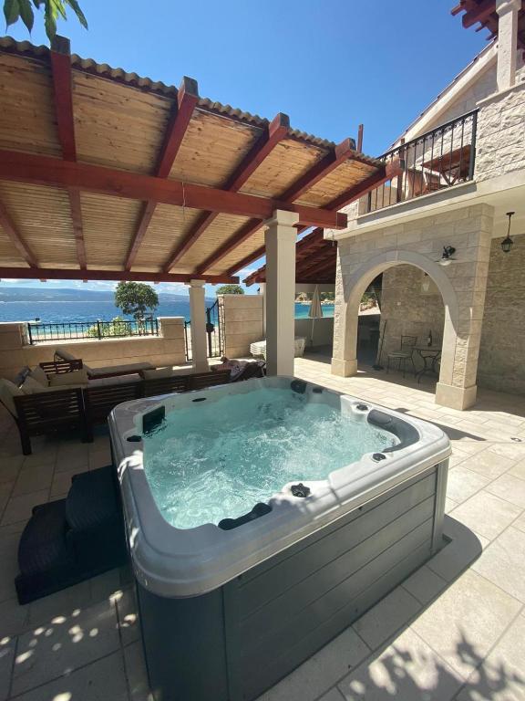a hot tub on a patio under a pergola at Beach Holiday Home Laura in Mimice