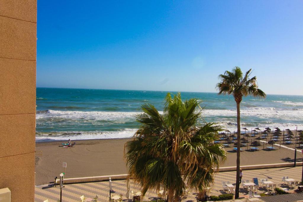 Blick auf einen Strand mit Palmen und das Meer in der Unterkunft Gold Mencía in Torrox Costa