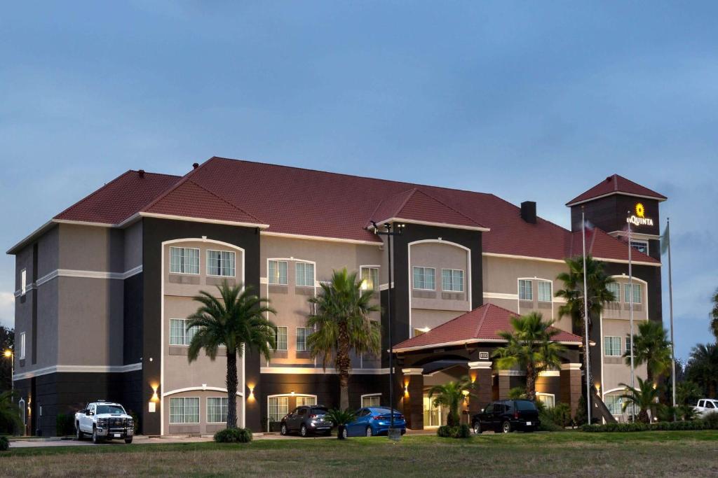 a large hotel with cars parked in front of it at La Quinta by Wyndham Alvin in Alvin