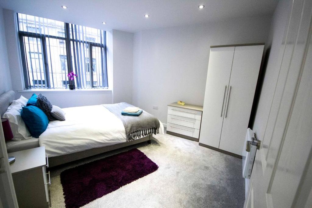 um pequeno quarto com uma cama e uma janela em StayZo - Executive City Centre Apartment 2 em Bradford