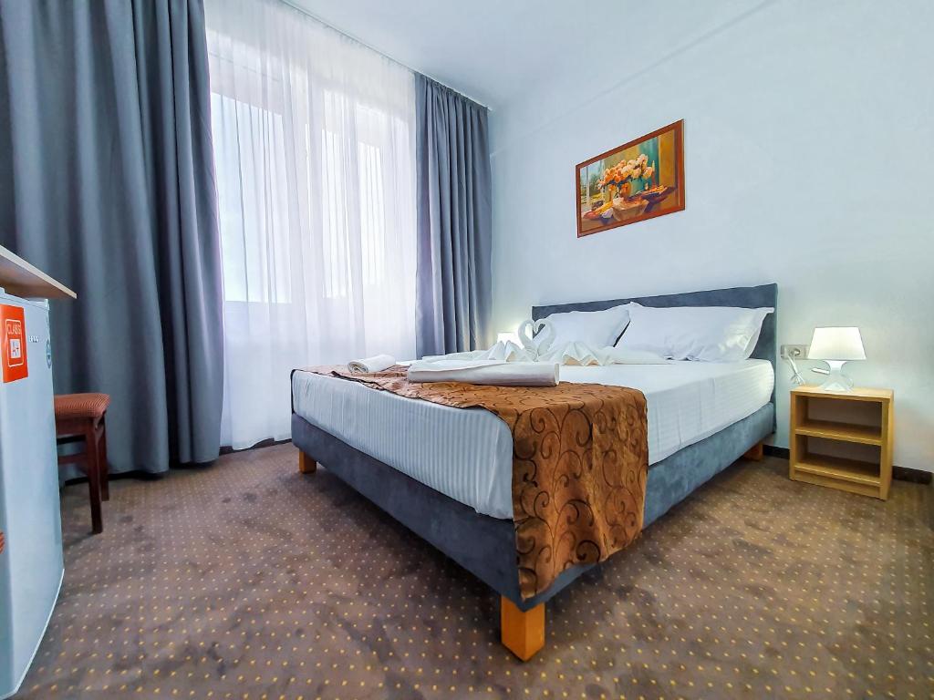 a hotel room with a bed and a window at Hotel Decebal Eforie Nord in Eforie Nord