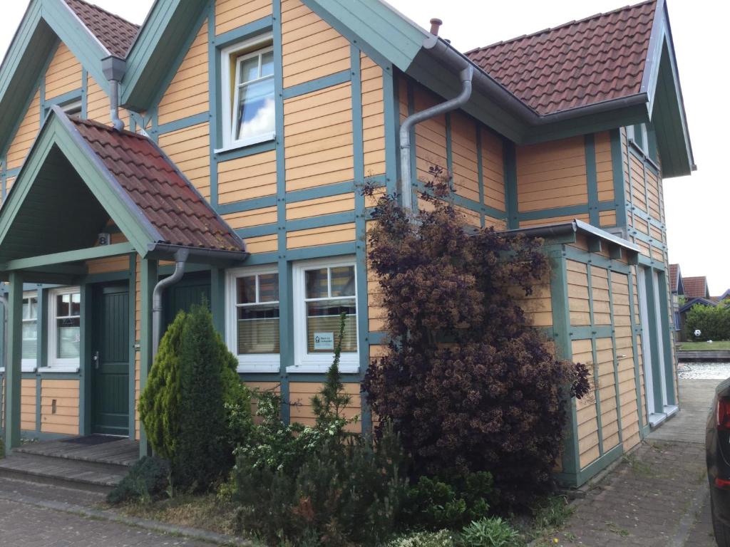 una casa amarilla con techo marrón en Ferienhaus ˋLichtblickˋ, en Rheinsberg
