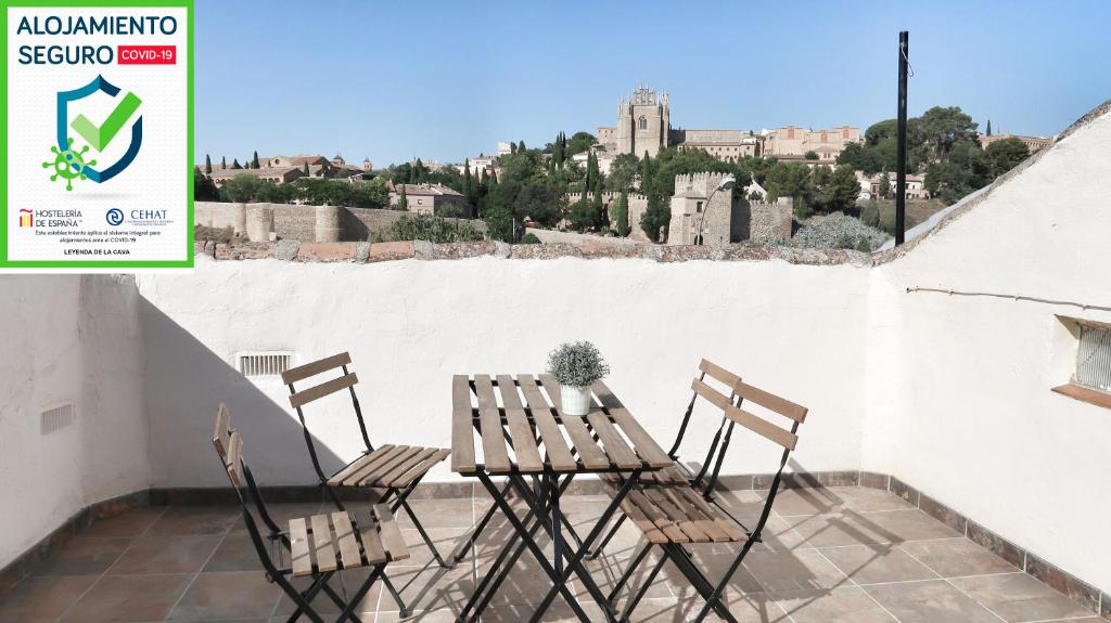 um par de cadeiras e uma mesa na varanda em Leyenda de la Cava em Toledo