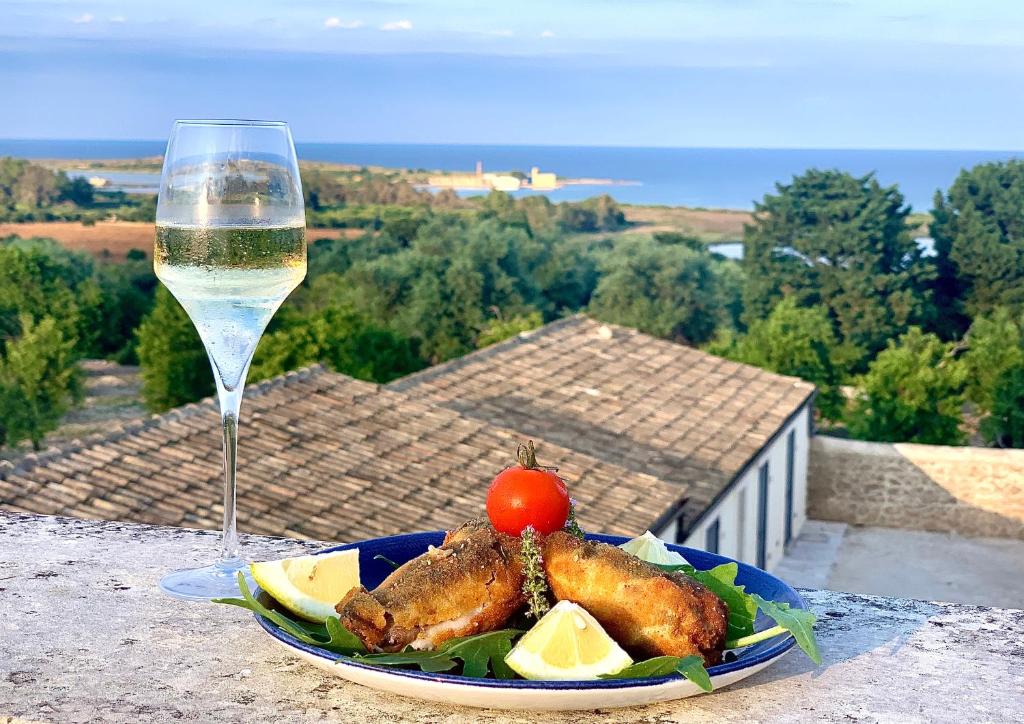 un plato de comida junto a una copa de vino en Pantanelli Di Vendicari, en Casa Maccari