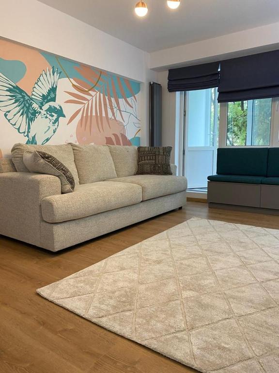 ein Wohnzimmer mit einem Sofa und einem Gemälde an der Wand in der Unterkunft Mery Luxury Apartment in Galaţi