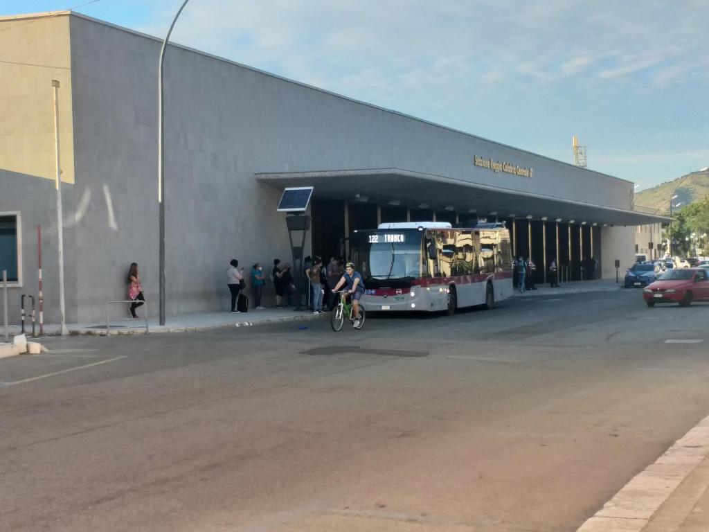 een bus geparkeerd buiten een gebouw met een persoon op een fiets bij Barlaam 3 in Reggio di Calabria