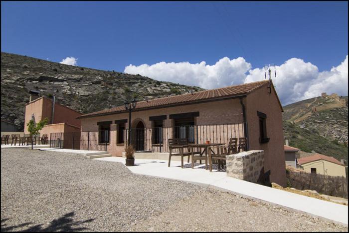 un pequeño edificio con una mesa delante en Apartamentos Barrena en Albarracín