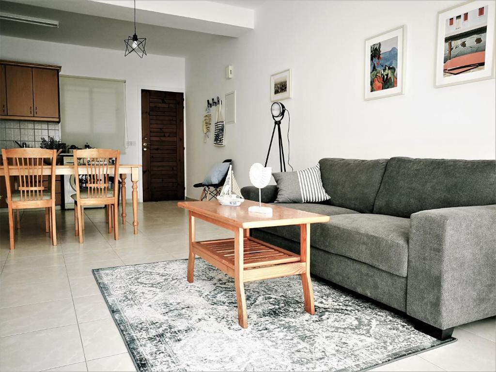 uma sala de estar com um sofá e uma mesa em Apartment Walnut103 with pool em Pafos