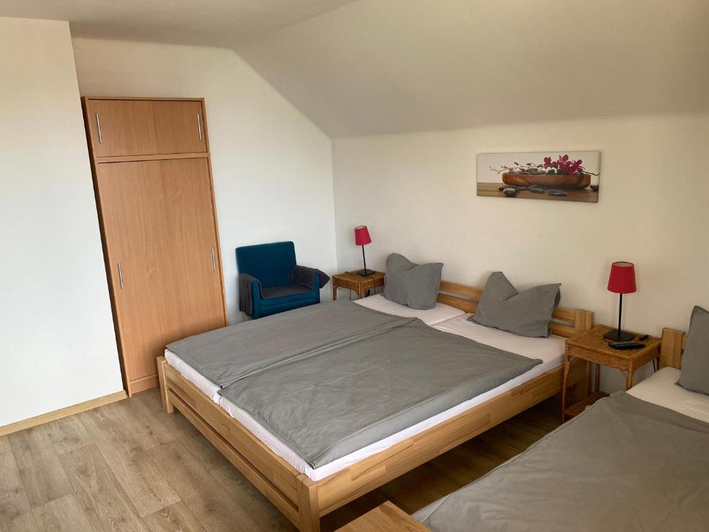 a bedroom with a bed and a blue chair at Ubytování U Kloučků v Potvorově in Potvorov