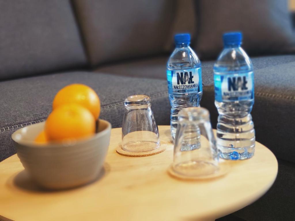 - deux bouteilles d'eau et un bol de fruits sur une table dans l'établissement Apartament Milbertus, à Sandomierz