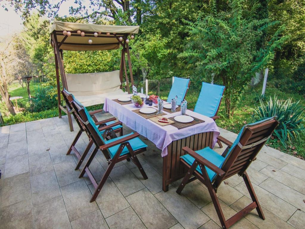 einen Tisch und Stühle auf einer Terrasse mit Pavillon in der Unterkunft Lovely holiday house with big private garden in Tuhelj