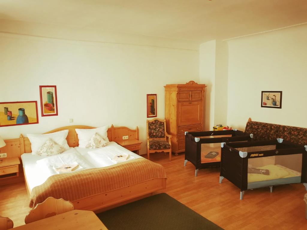 ein Schlafzimmer mit einem Bett, einem Sofa und einem Stuhl in der Unterkunft Gästehaus Reisinger in Straubing