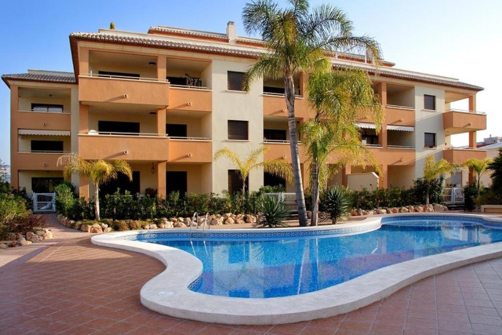 a resort with a swimming pool in front of a building at Arenal Cannes in Jávea