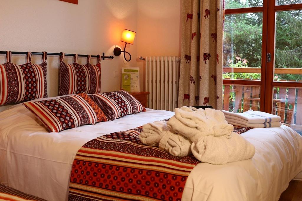 1 dormitorio con 2 camas y toallas. en Hotel-Restaurant Spa Les Peupliers, en Baratier