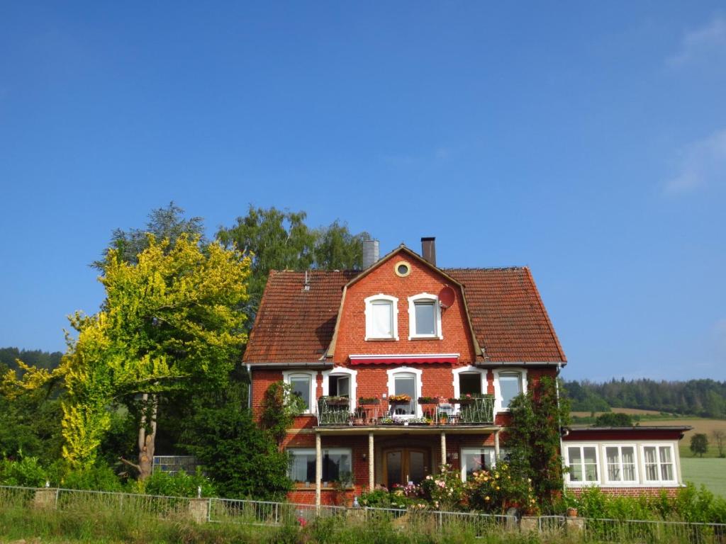 a large red house with a balcony at Gästezimmer im Freudenthal in Extertal