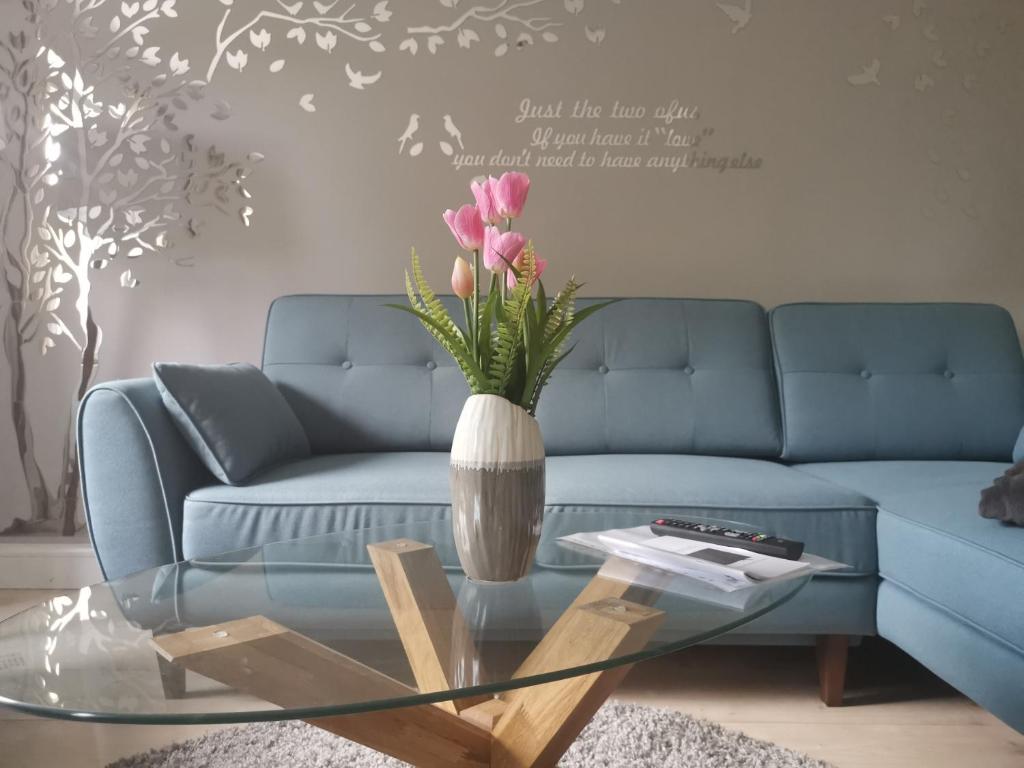 un soggiorno con divano blu e vaso con fiori di harz-traum.2 a Gernrode - Harz