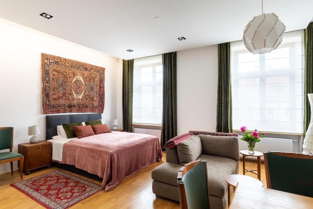ein Schlafzimmer mit einem Bett und einem Sofa in der Unterkunft Pałac Zieleniewskich Apartamenty św Marka 31 in Krakau