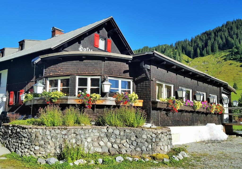 a house with flowers in front of it at Gasthof Auerhahn in Lech am Arlberg