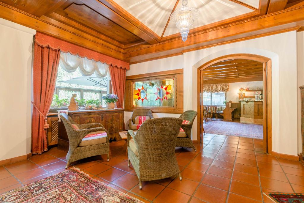 a living room with chairs and a table and a mirror at Hotel Monte Civetta in Alleghe