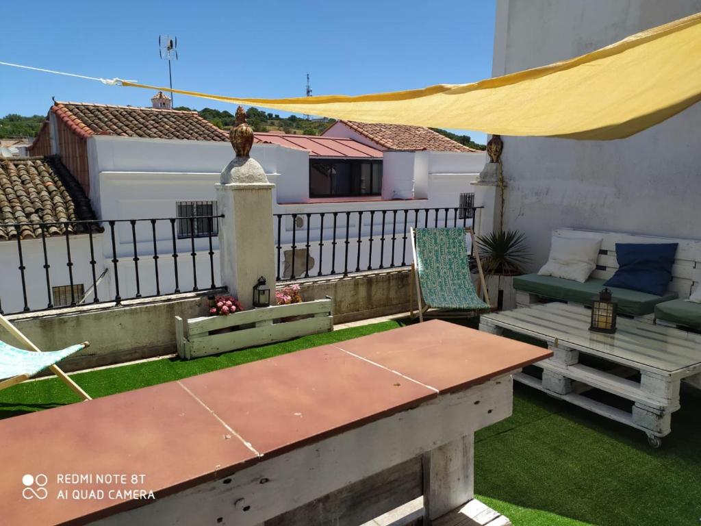 a patio with a table and a bench on a balcony at Casa de La Abuela Pepi in Aracena