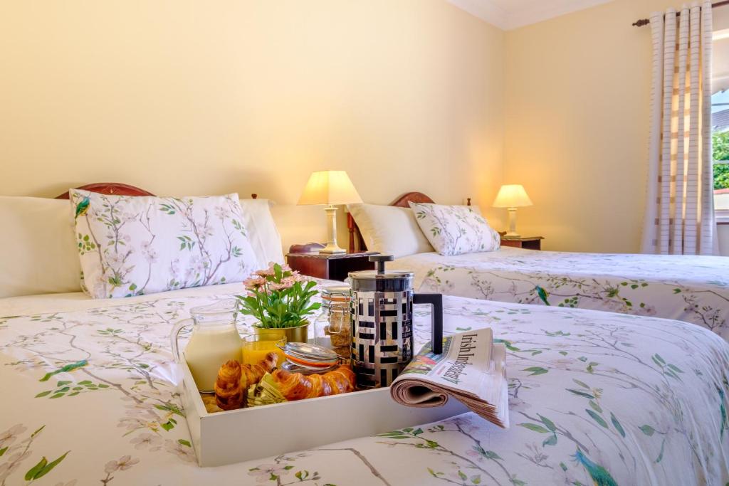 a hotel room with two beds with a tray of food at Fallon's B&B in Kinvara