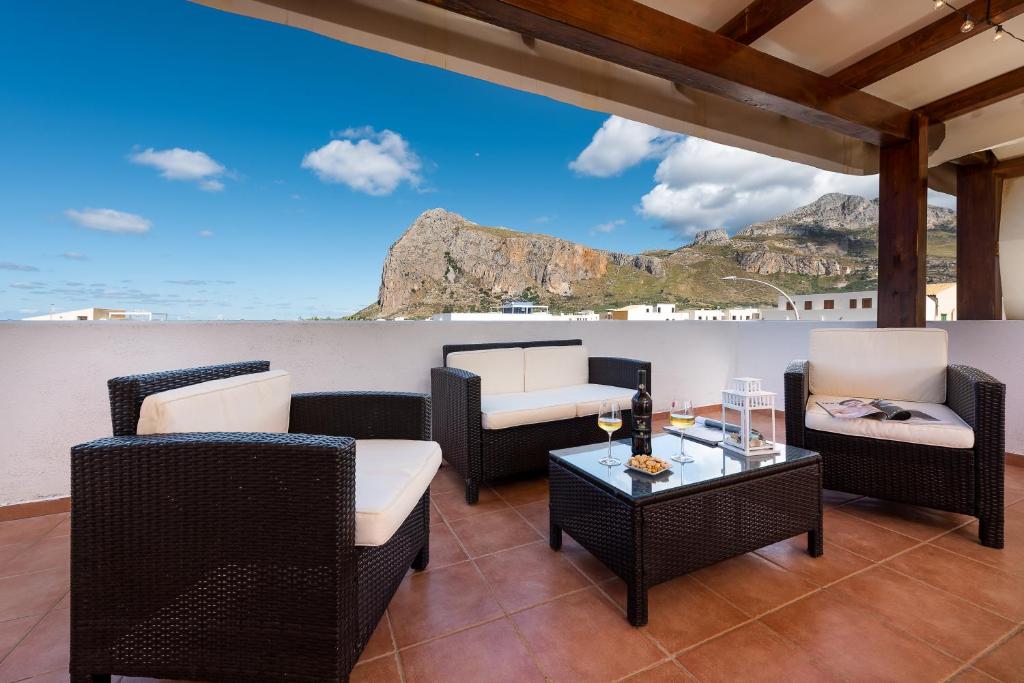 un patio con sedie e tavoli e vista sull'oceano di I Tre Golfi - Appartamenti con Terrazzo fino a 800 mt dal mare a San Vito lo Capo