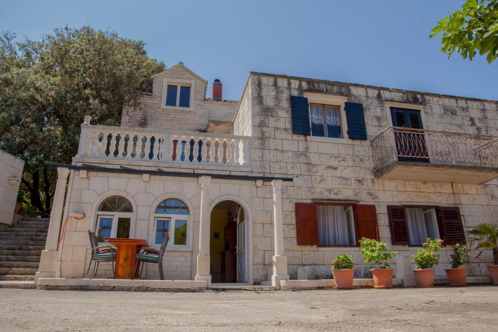 an old house with a table in front of it at Apartment Curri in Pučišća
