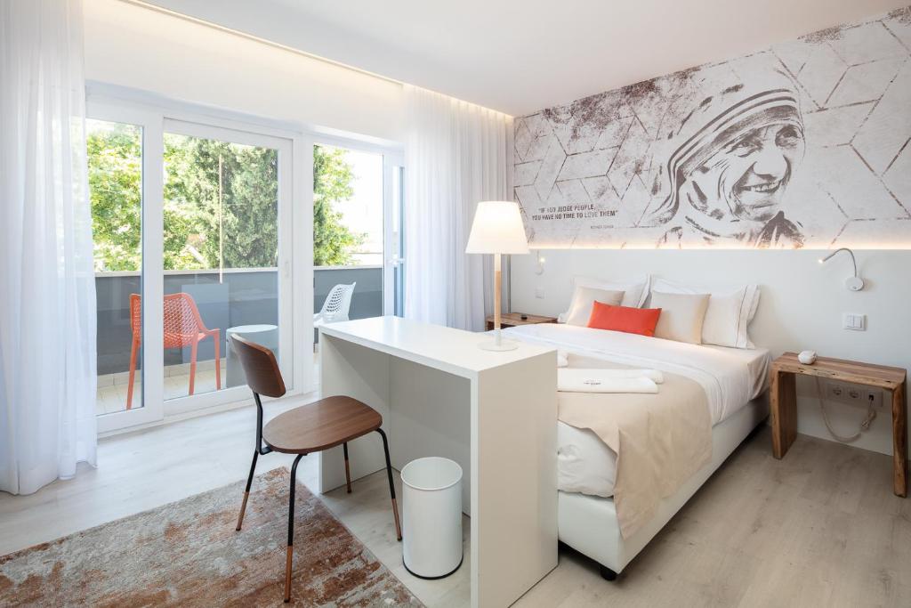 een slaapkamer met een kingsize bed en een bureau bij The ICONS Lisbon Central Hotel in Lissabon