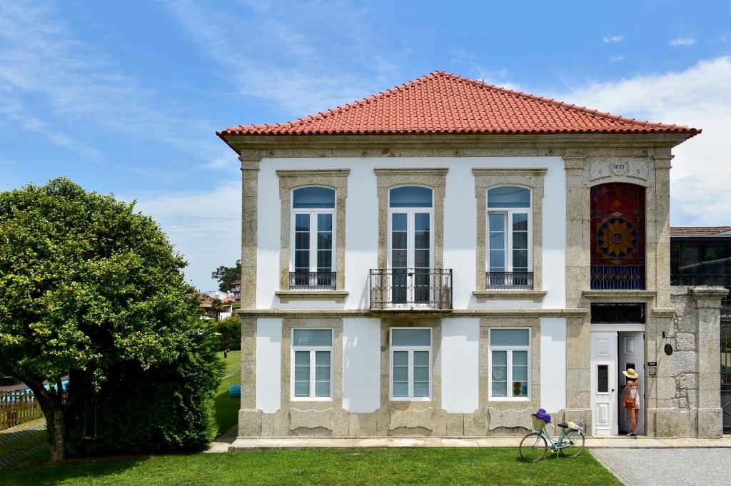 una gran casa blanca con techo rojo en Solar Egas Moniz-Charming House & Local Experiences, en Paço de Sousa