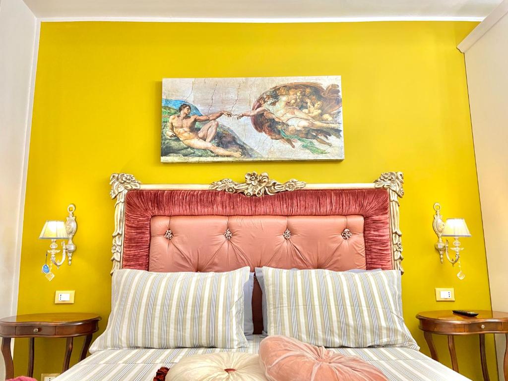 a yellow bedroom with a bed with a pink headboard at Casa delle Gioie in Syracuse