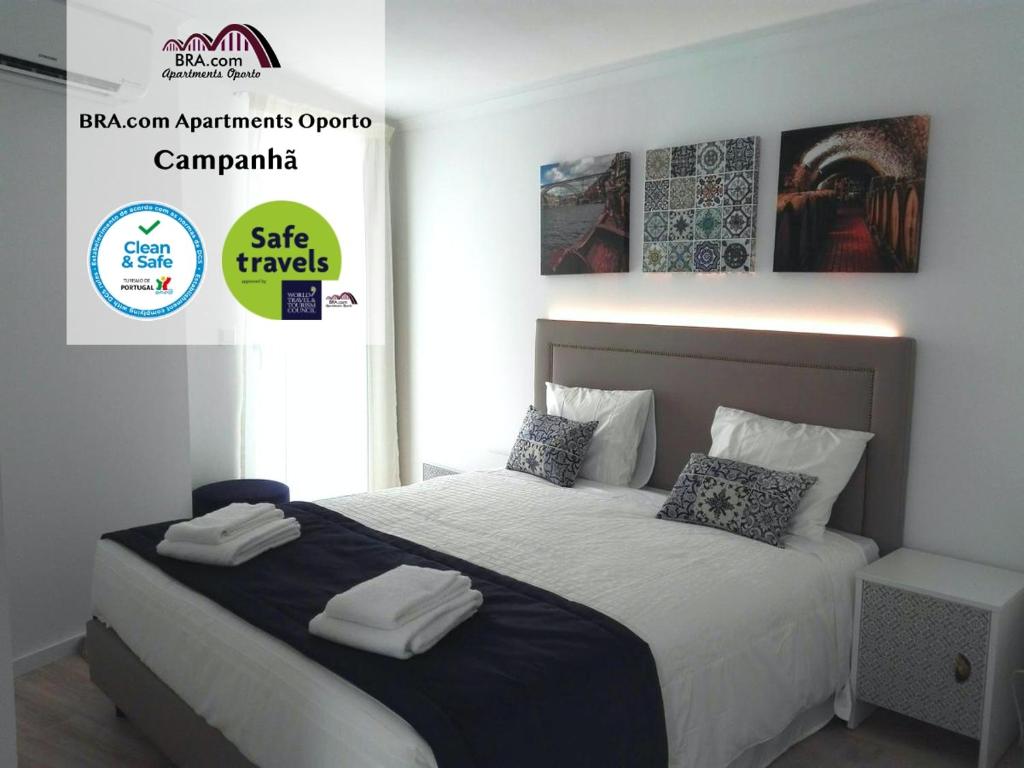a bedroom with a bed with white sheets and pillows at BRA.com Apartments Oporto Campanhã in Porto