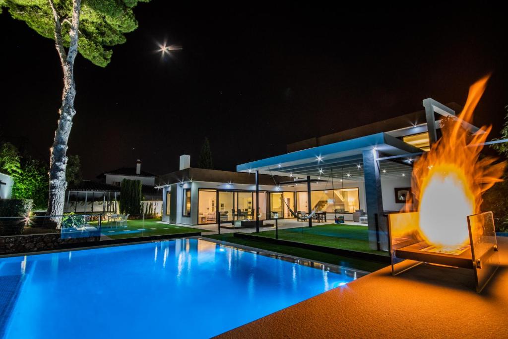 una casa con una gran piscina por la noche en Cubo's Villa Elena, en Alhaurín el Grande