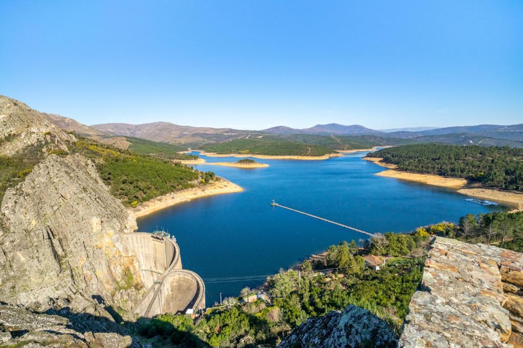 een uitzicht op een rivier met een boot in het water bij ARADAS, Pampilhosa da Serra, Casa da Oliveira, Wifi, Ar Condicionado, Churrasqueira, Parqueamento, by IG in Unhais-o-Velho