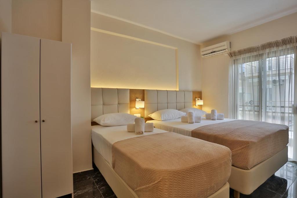 a bedroom with two beds and a window at Olympus and Zeus in Olympic Beach