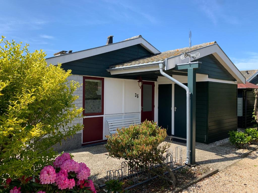 a small house with a sign in front of it at Bungalow36 - Petten in Petten