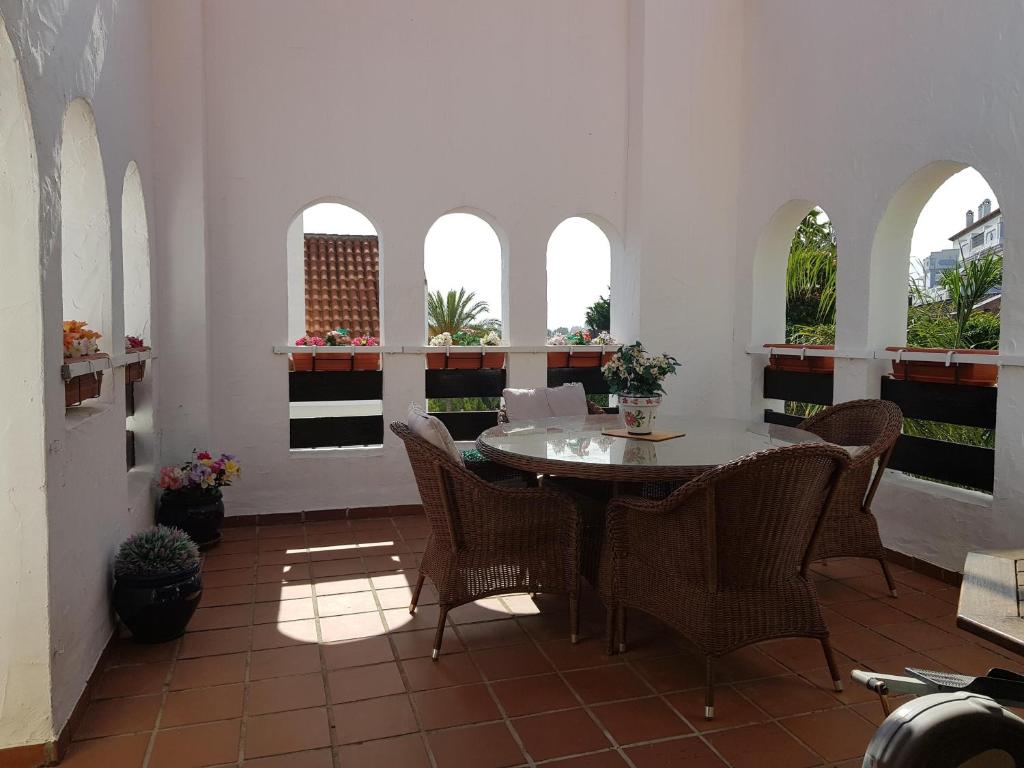 a dining room with a table and chairs and windows at LA MAESTRANZA in Marbella