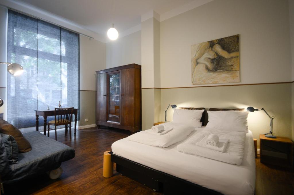 柏林的住宿－Altbauwohnung mit 3 Bädern (PB6)，卧室配有床、椅子和窗户。