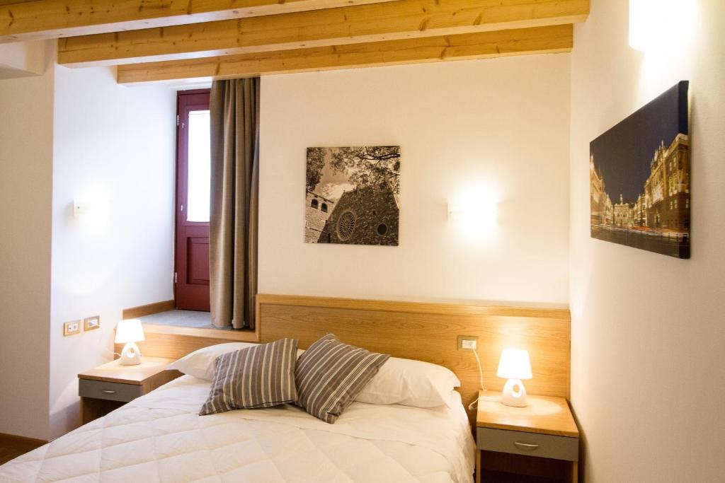 a bedroom with a bed with two night stands and two lamps at Hotel All'Arco in Trieste