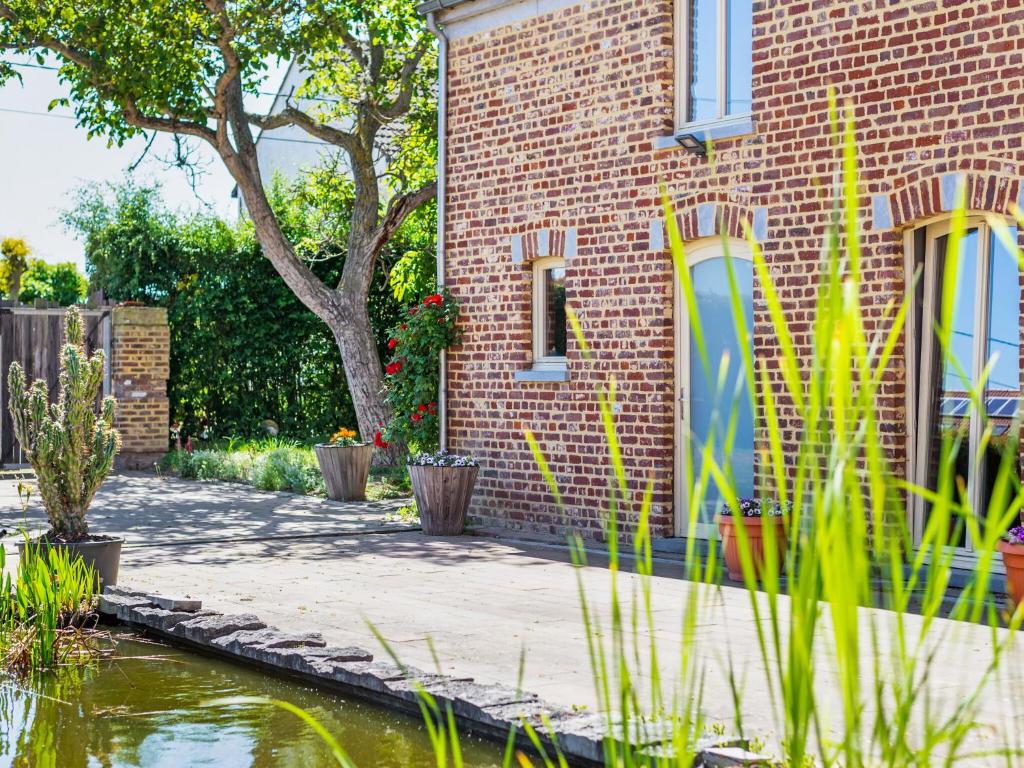 a brick building with a pond in front of it at Cozy apartment in the hiking and cycling kingdom of Geetbets in Geetbets