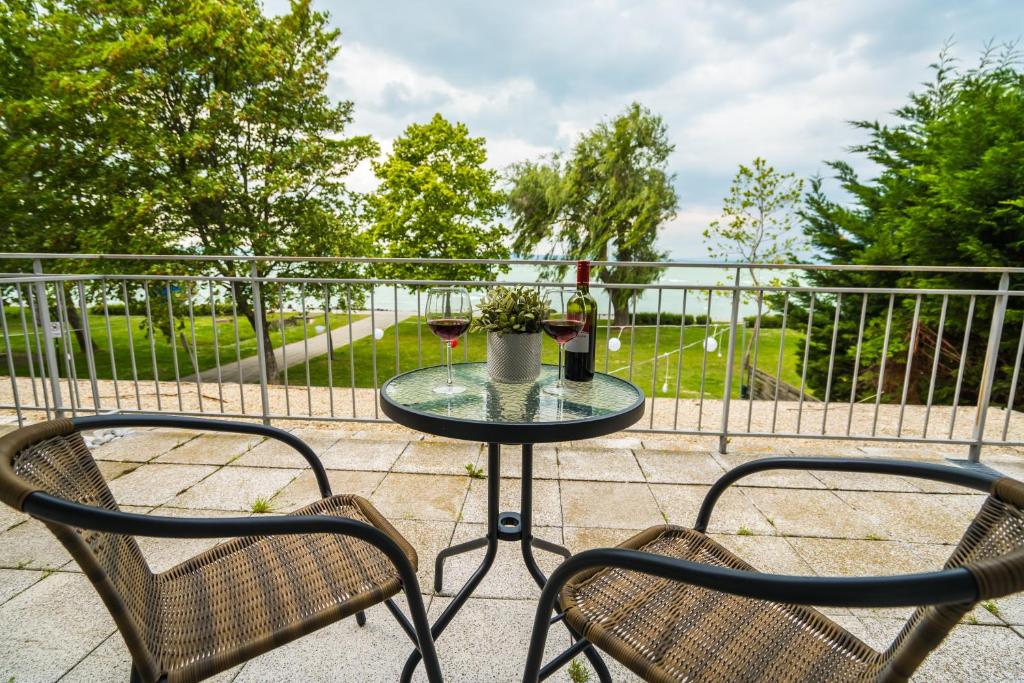 een tafel en 2 stoelen op een balkon bij Siesta Sziget - Balaton-parti Apartmanok in Siófok