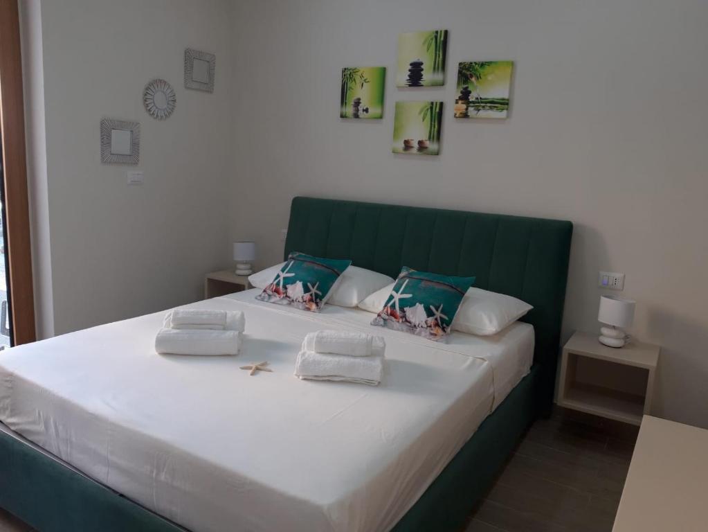 una camera con un grande letto con testiera verde di B&B Mediterraneo a Cetraro