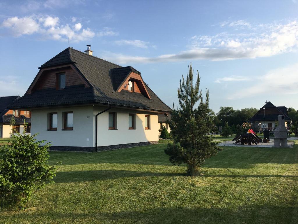 une maison avec un arbre dans la cour dans l'établissement Chalet Jayata, à Stará Lesná