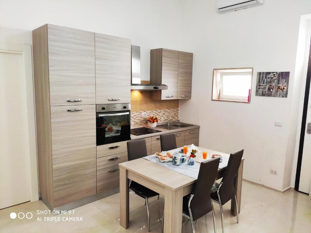 uma cozinha com mesa e cadeiras e uma cozinha com fogão em Casa Mamy 37 em Barletta