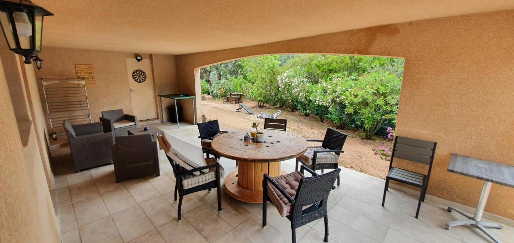 a room with a table and chairs and a large window at Bel appartement dans hameau calme in Bonifacio