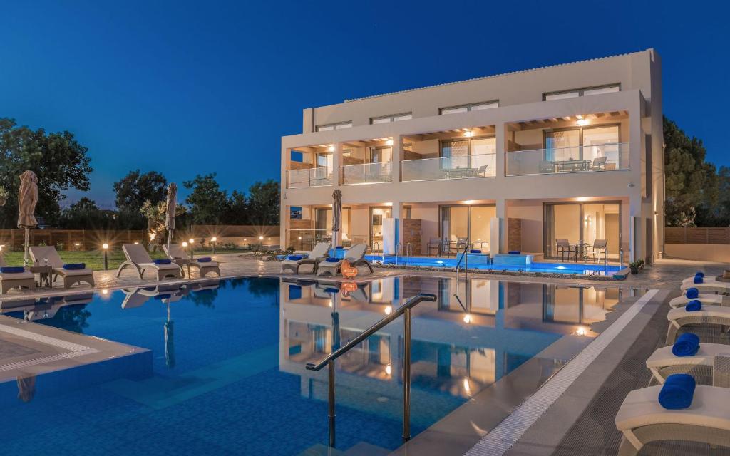 una grande casa con piscina di notte di Mystique Luxury Suites & Maisonettes a Laganas