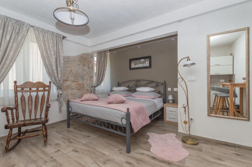 a bedroom with a bed and a chair and a mirror at Bossa Studio Apartments in Split
