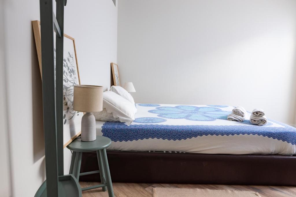 ein Schlafzimmer mit einem Bett mit einem Hocker daneben in der Unterkunft Vale71house in Porto